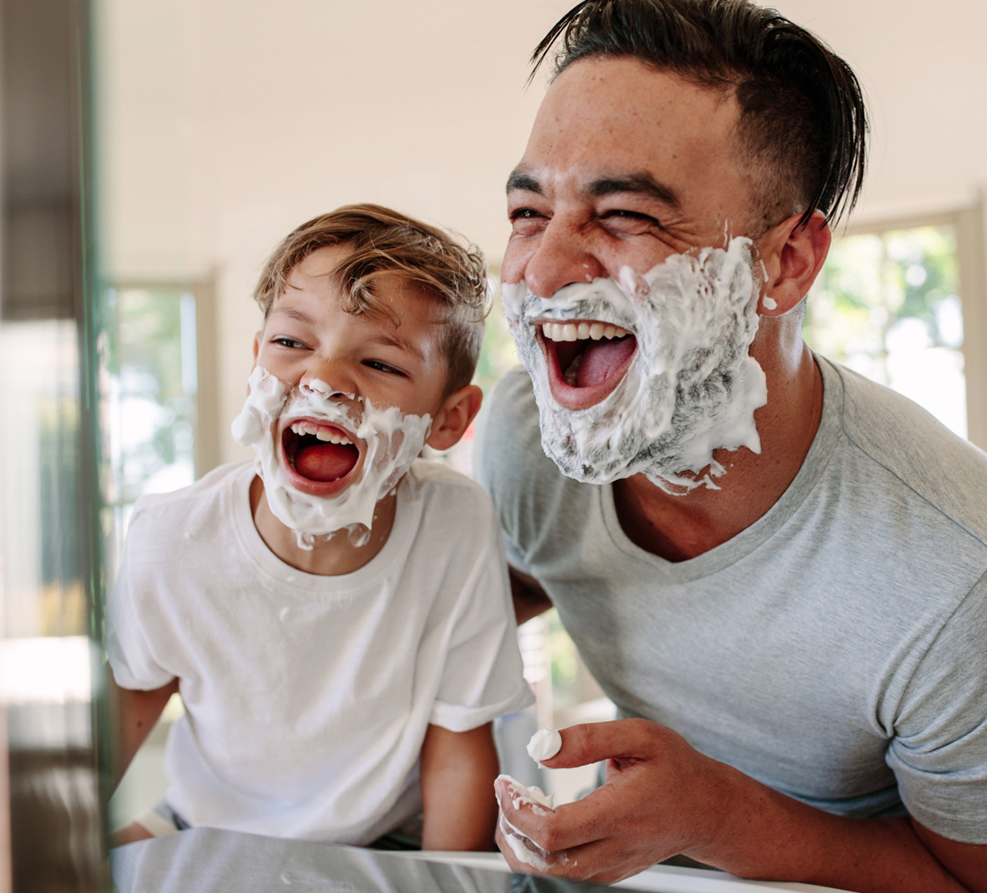 Father and son having fun learning to shave